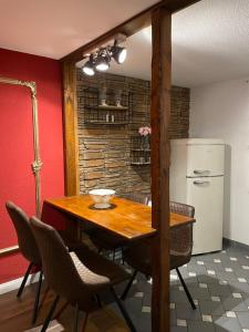 La cuisine est équipée d'une table et de chaises en bois ainsi que d'un réfrigérateur. dans l'établissement Gemütliches Häuschen, à Schwerin