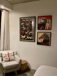 a living room with a chair and pictures on the wall at The CIVYT in Ubud