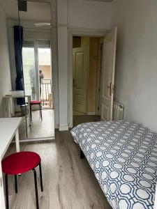 1 dormitorio con 1 cama, mesa y sillas en Habitaciónes Luminosas y acogedoras, en Madrid