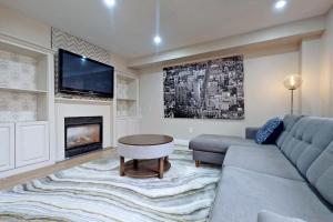 a living room with a couch and a tv at Superhouse with space for all! in Pickering
