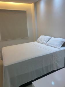 a bed with white sheets and pillows in a room at Reserva das praias in Manaus