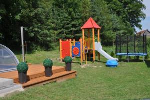 a playground with a slide and a playset at Domek Bagienice z basenem in Mrągowo