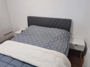 1 dormitorio con cama con colcha gris en Apartman Virgin Forest - FREE Garage Bjelašnica en Bjelašnica