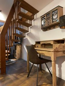 einen Holzschreibtisch mit einem Stuhl neben einer Treppe in der Unterkunft Gemütliches Häuschen in Schwerin