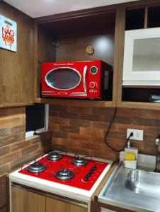 a red microwave above a stove in a kitchen at Flat na Rua XV 2107 in Curitiba