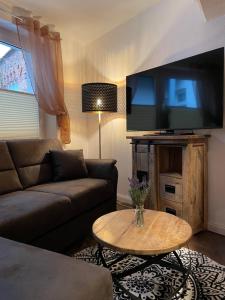 ein Wohnzimmer mit einem Sofa und einem Tisch in der Unterkunft Gemütliches Häuschen in Schwerin