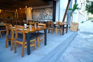 un restaurant avec des tables et des chaises en bois sur une terrasse dans l'établissement Hotel Cordelia Resort & Spa, à Loreto