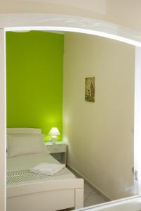 um quarto com uma parede verde e uma cama em Aspasia Studios em Lixouri