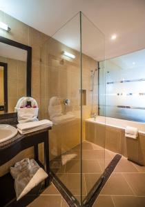 La salle de bains est pourvue d'une douche, d'un lavabo et d'une baignoire. dans l'établissement Acacia Premier Hotel, à Kisumu
