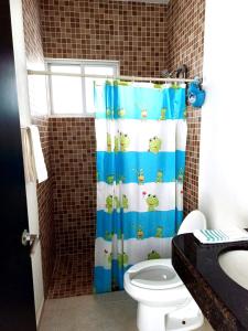 a bathroom with a shower curtain with a toilet at Bella Casa Familiar in Cancún +14 photos