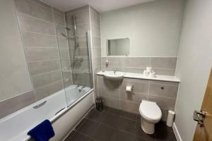 a bathroom with a toilet and a tub and a sink at Beautiful Roomy Studio Central Manchester Sleeps 2 in Manchester