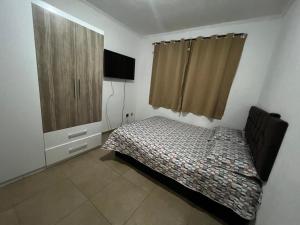Schlafzimmer mit einem Bett und einem Holzschrank in der Unterkunft ap centro campinas in Campinas