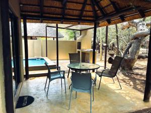 a patio with a table and chairs and a pool at Athule Marloth in Marloth Park