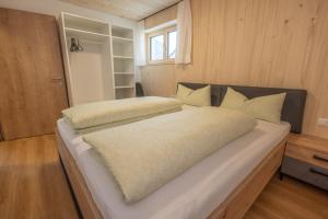 Cette chambre comprend un grand lit blanc et une fenêtre. dans l'établissement Ferienwohnung Himmelmoos, à Au im Bregenzerwald