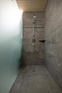 La salle de bains est pourvue d'une douche et d'un mur en pierre. dans l'établissement Ferienwohnung Himmelmoos, à Au im Bregenzerwald