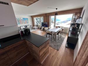 une cuisine avec une table et un salon dans l'établissement Best view in Crans Montana, à Crans-Montana