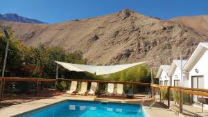 una piscina con una montaña en el fondo en Cabañas Imperio Pisco Elqui en Pisco Elqui