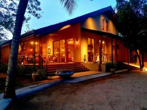 a house with a palm tree in front of it at Allure Yala Luxury Suites by Allure Leisure in Yala