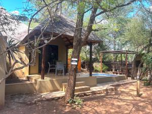 a house with a thatched roof and a swimming pool at Athule Marloth in Marloth Park