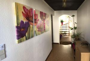 フュルトにあるFerien-und-Messeappartement-Falkeの壁に花三本の絵画が飾られた廊下