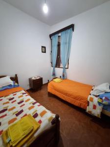 a bedroom with two beds and a window at A Lau' De Los Álamos in Humahuaca