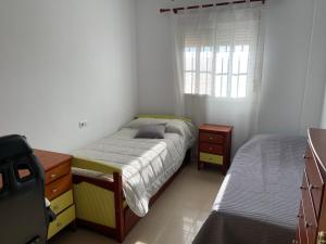- une chambre avec un lit, une commode et une fenêtre dans l'établissement Casa Bornes, à Sanlúcar de Barrameda