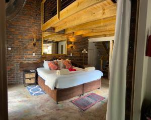 a bedroom with a large bed in a brick wall at Athule Marloth in Marloth Park