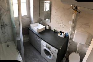 a bathroom with a washing machine and a sink at Next to Paris Metro - Calm & Convenient Apartment in Villejuif