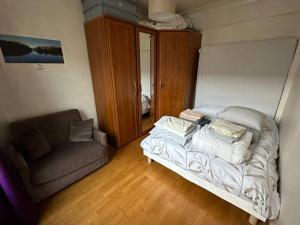 ヴィルジュイフにあるNext to Paris Metro - Calm & Convenient Apartmentの小さなベッドルーム(ベッド1台、ソファ付)