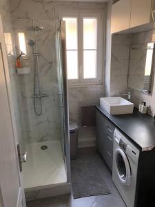 a bathroom with a shower and a washing machine at Next to Paris Metro - Calm & Convenient Apartment in Villejuif
