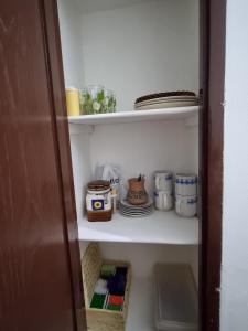 a pantry with dishes and plates on a shelf at A Lau' De Los Álamos in Humahuaca