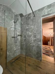a shower with a glass door in a bathroom at Apartments Mandry in Yaremche