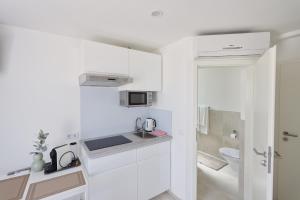 a small kitchen with white cabinets and a sink at Apartment R A M L J A K - Apartman "Rafael" in Vodice +25 photos