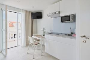 a white kitchen with a table and a counter top at Apartment R A M L J A K - Apartman "Rafael" in Vodice