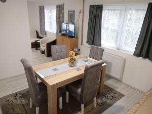 comedor con mesa de madera y sillas en Apartman Branka, en Niška Banja