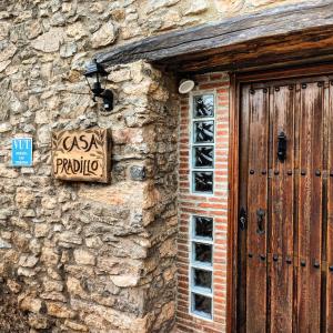 a sign on the side of a stone building with a door at Casa Pradillo 