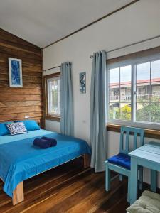 ボカス・タウンにあるCasa Pelicanoのベッドルーム(青いベッド1台、窓付)