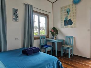 博卡斯德爾托羅的住宿－Casa Pelicano，一间卧室配有一张床、两把椅子和一个窗户