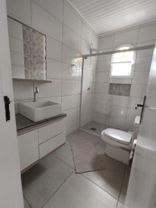 Baño blanco con lavabo y aseo en Residencial Dete, en Florianópolis