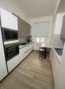een keuken met witte apparatuur en een houten vloer bij Lucia's home in Occhiobello
