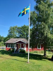 a flag on a pole in front of a house at Lilla Röaby in Bräkne-Hoby