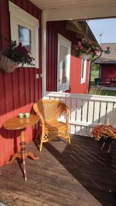 una mesa de mimbre y una silla en el porche de una casa en Lilla Röaby, en Bräkne-Hoby