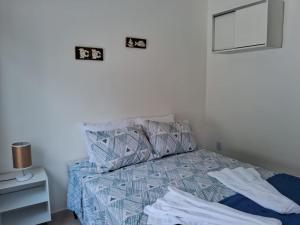 um quarto com uma cama com lençóis azuis e um espelho em Recanto Ganesha seu paraíso na praia, no Recanto de Itaipuaçu ao lado de Itacoatiara em Itacoatiara