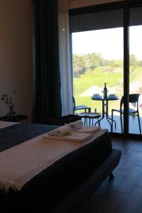 a bedroom with a bed with a view of a golf course at Zambujal Suites in Sesimbra