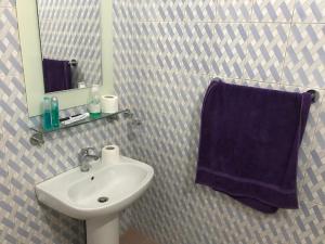 a bathroom with a sink and a blue towel at Maison meublée a thies. in Thiès
