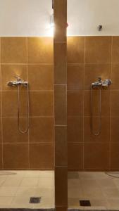 a bathroom with two shower heads and brown tiles at Dar Gara in Tangier +60 photos