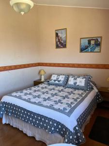 a bedroom with a bed with blue and white sheets at El Mirador De Valparaiso in Valparaíso