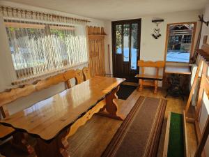 a wooden table in a room with a window at Apartamenty Cicha Dolina in Jurgów