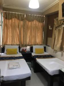 um quarto com duas camas e uma janela em Temple Street Hotel em Hong Kong