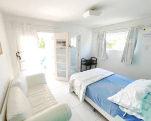 ブジオスにあるCasa maravilhosa com vista para o mar 50mt da Orlaの白いベッドルーム(ベッド1台、窓付)